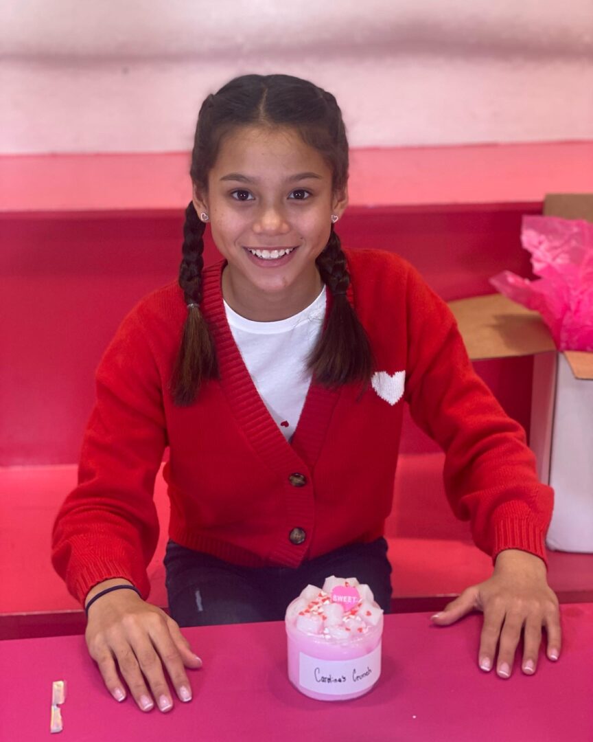 A teen wearing a red knitted jacket over a white shirt