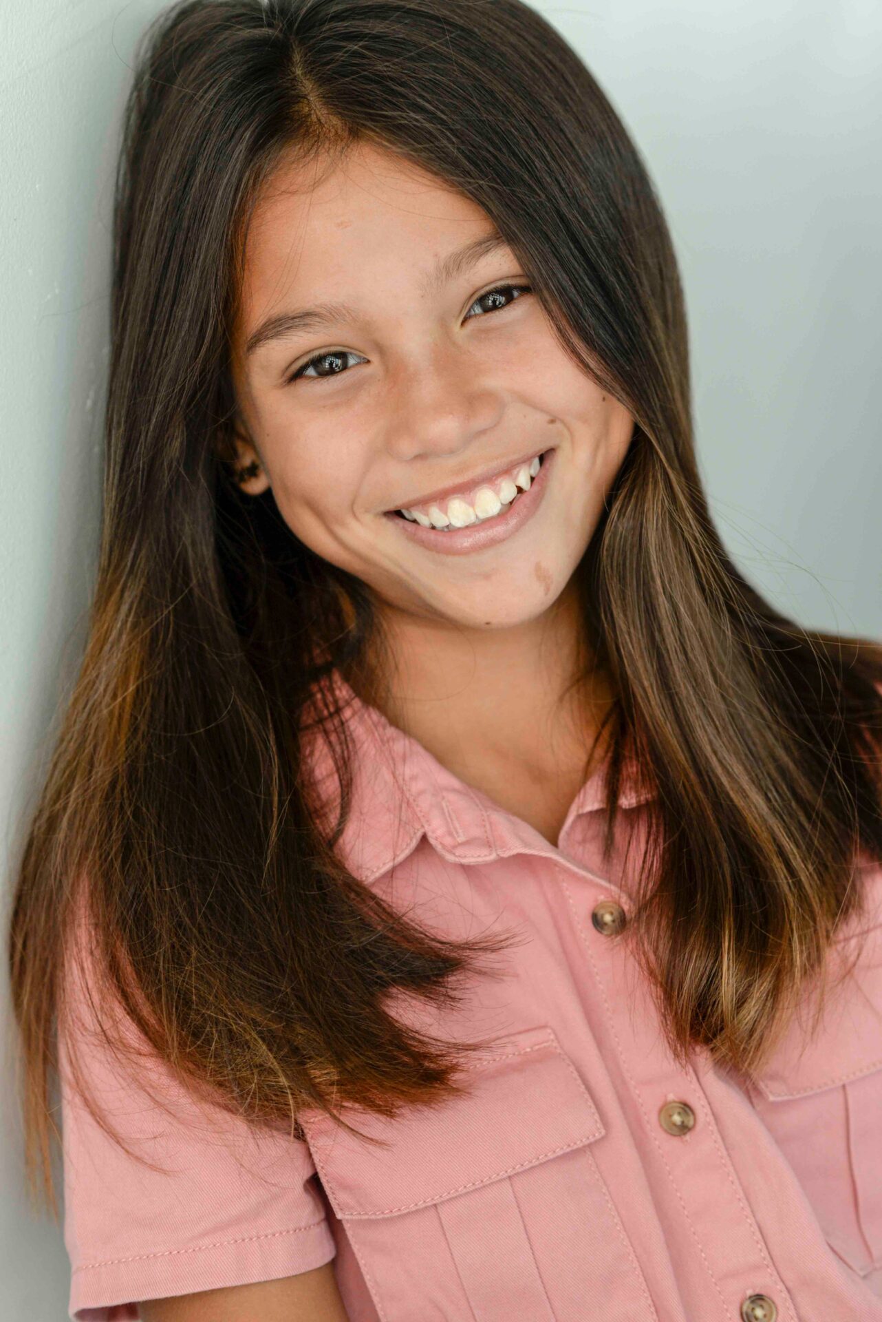 A teen with long hair smiling at the camera