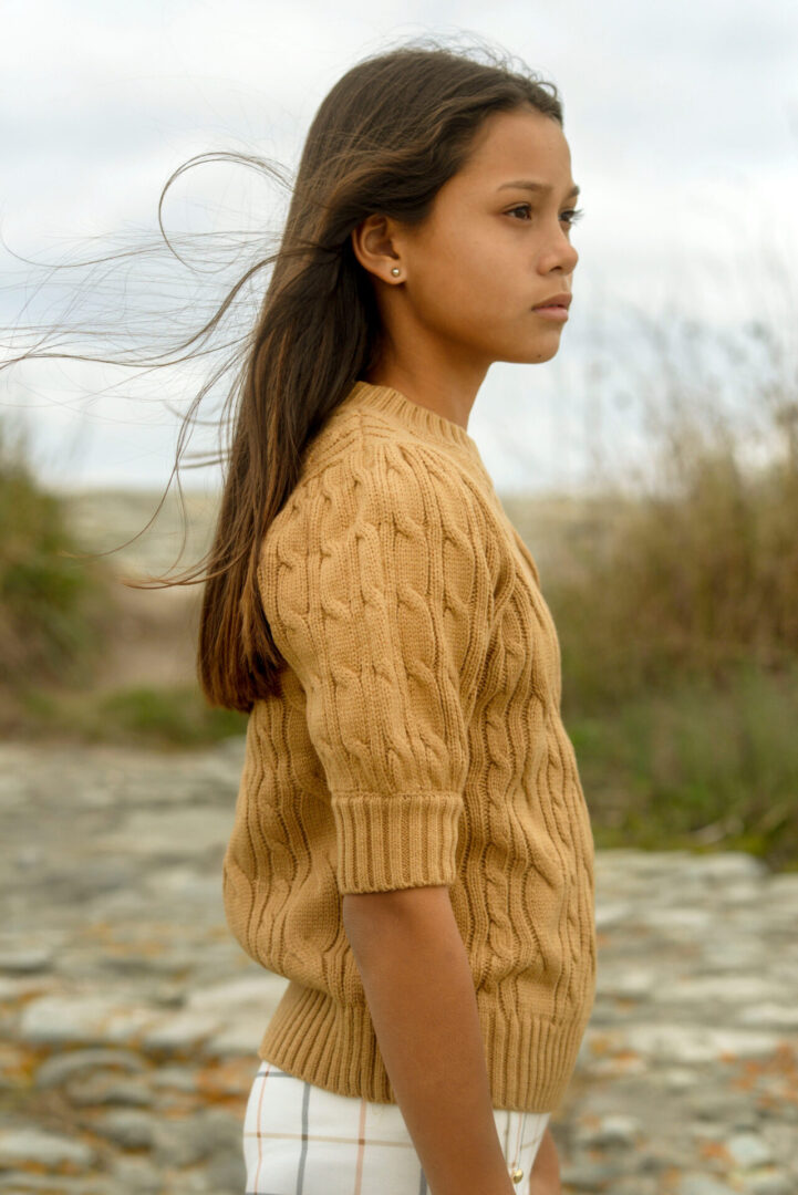 Girl wearing yellow sweater posing at the camera