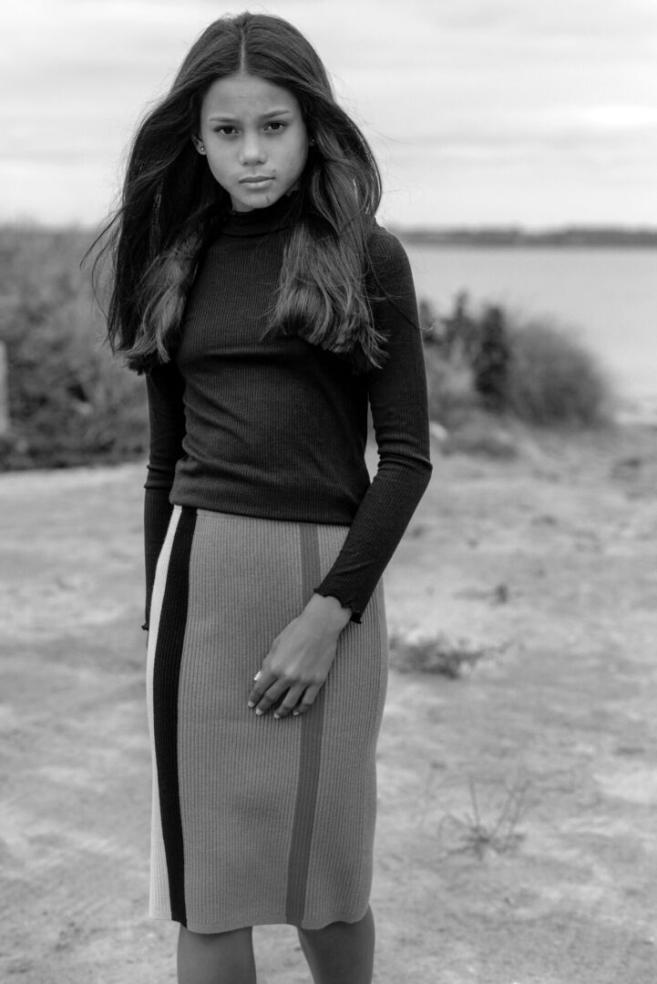 Black and white image of a girl walking in a field