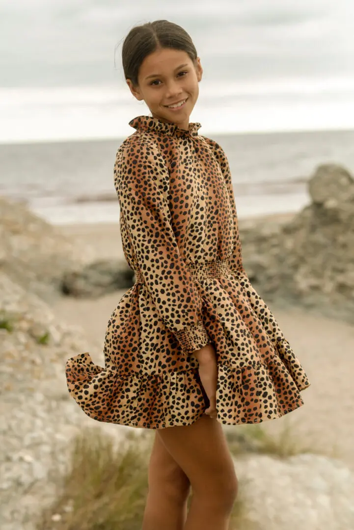 Girl wearing a tiger print dress, smiling at the camera