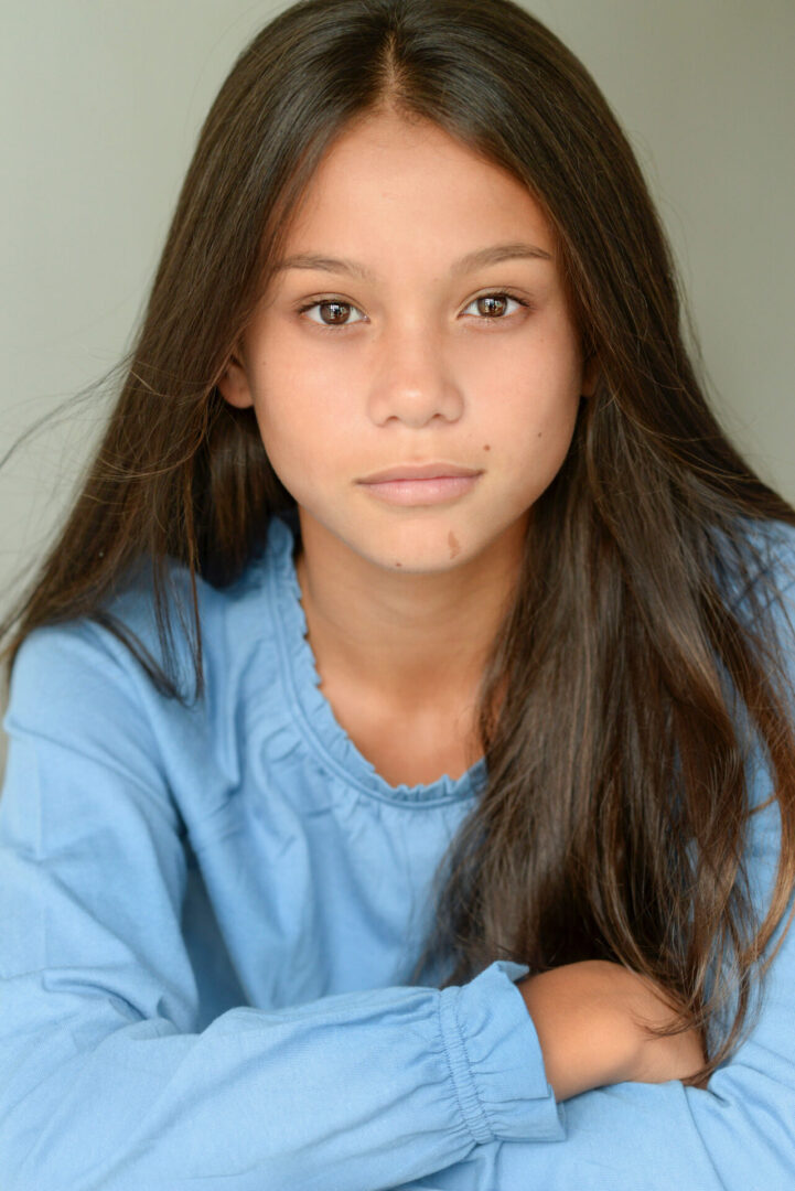 Girl wearing blue dress, smiling at the camera