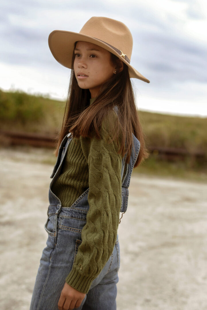 Caroline Quinn walking and wearing a cowboy hat