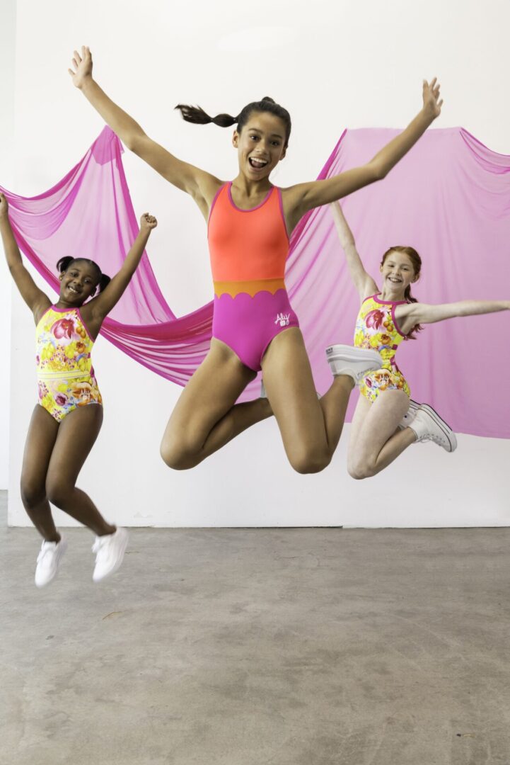 Three girls wearing swimsuit jumping